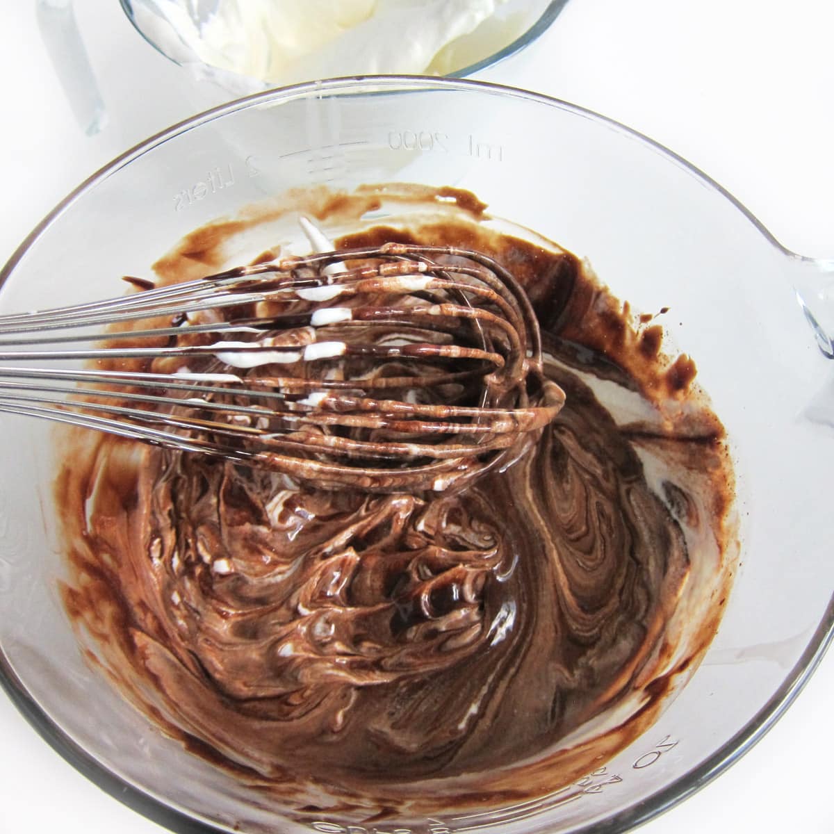 folding whipped cream into melted chocolate using a whisk