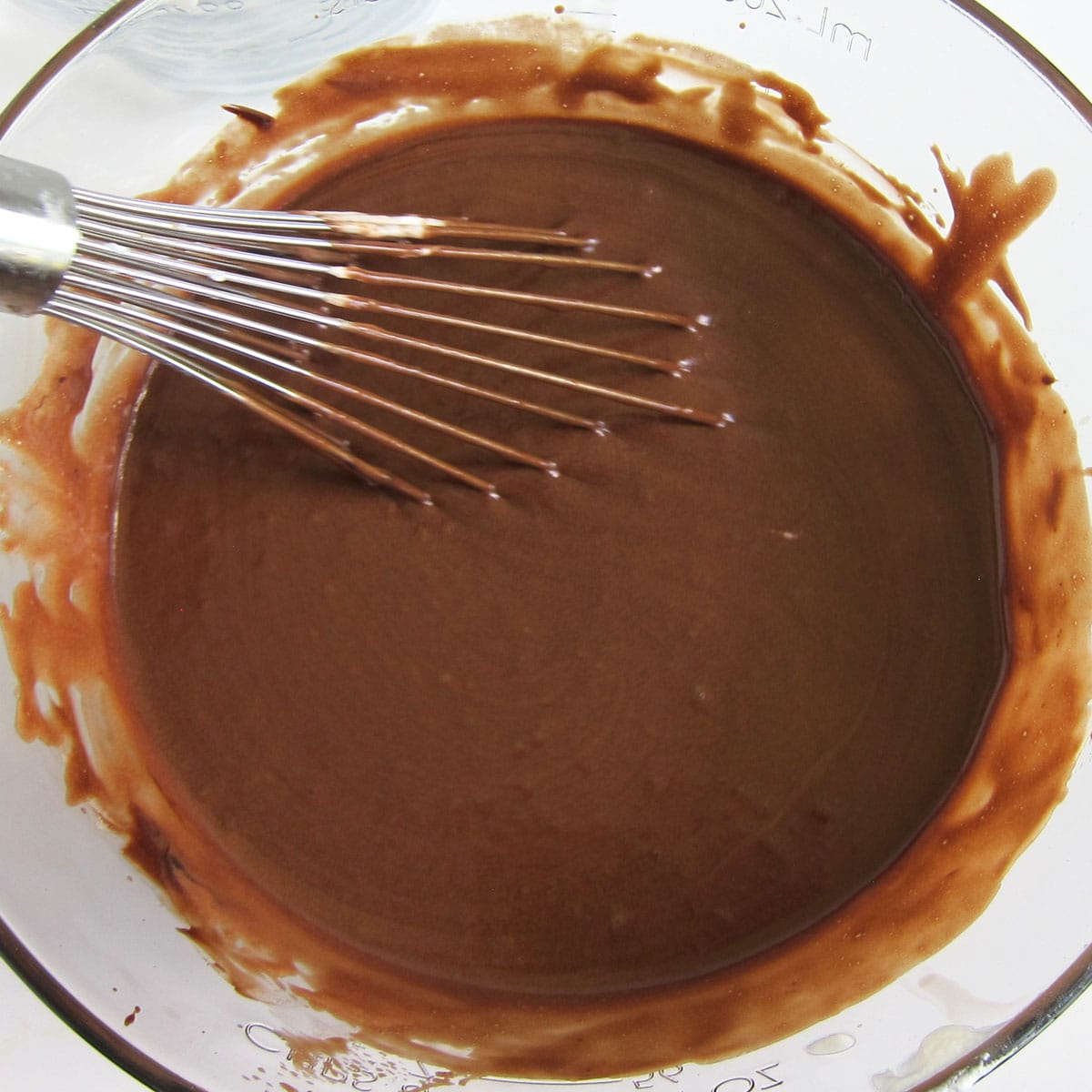 Chocolate mousse blended with a whisk in a mixing bowl.