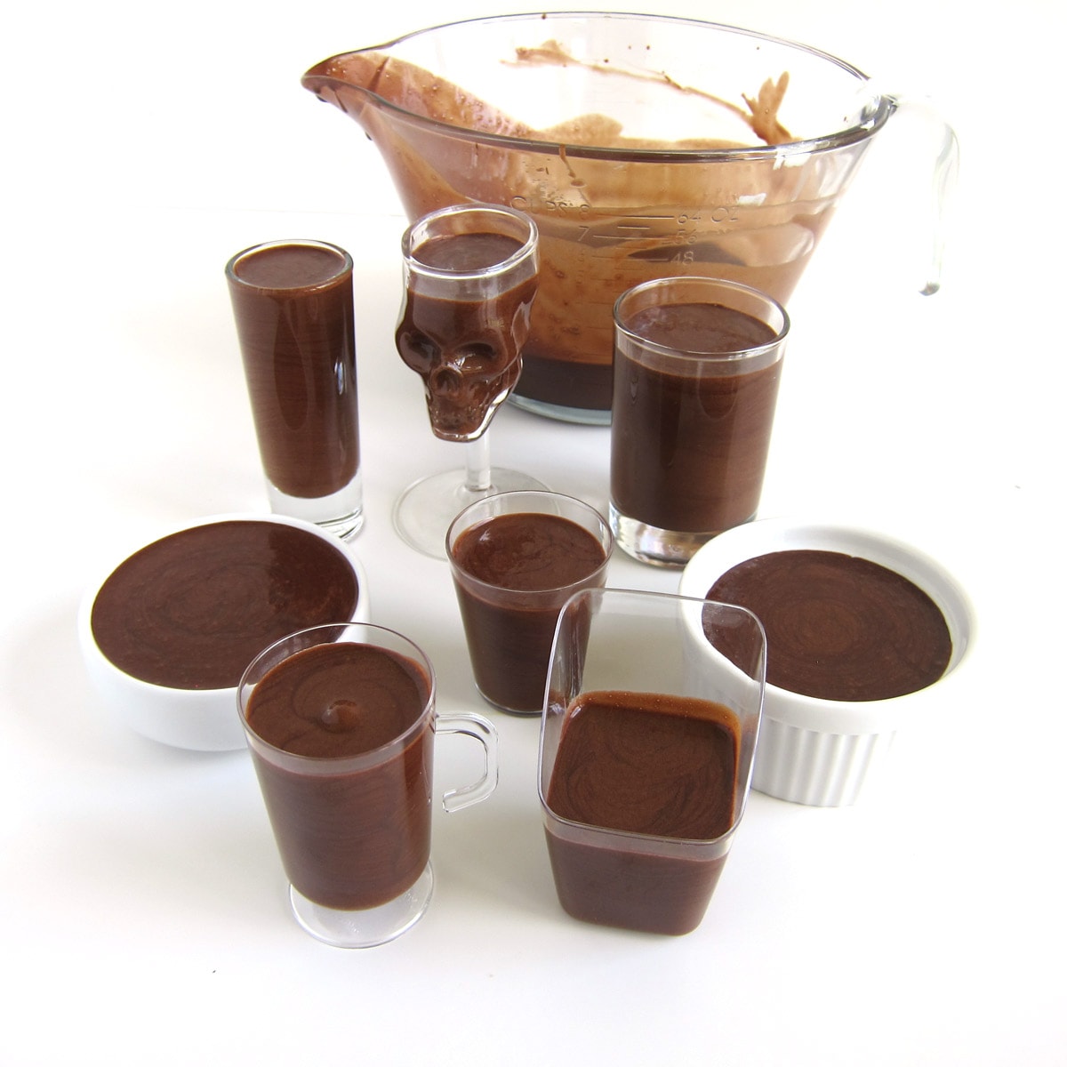 Chocolate mousse in a variety of cups and bowls.