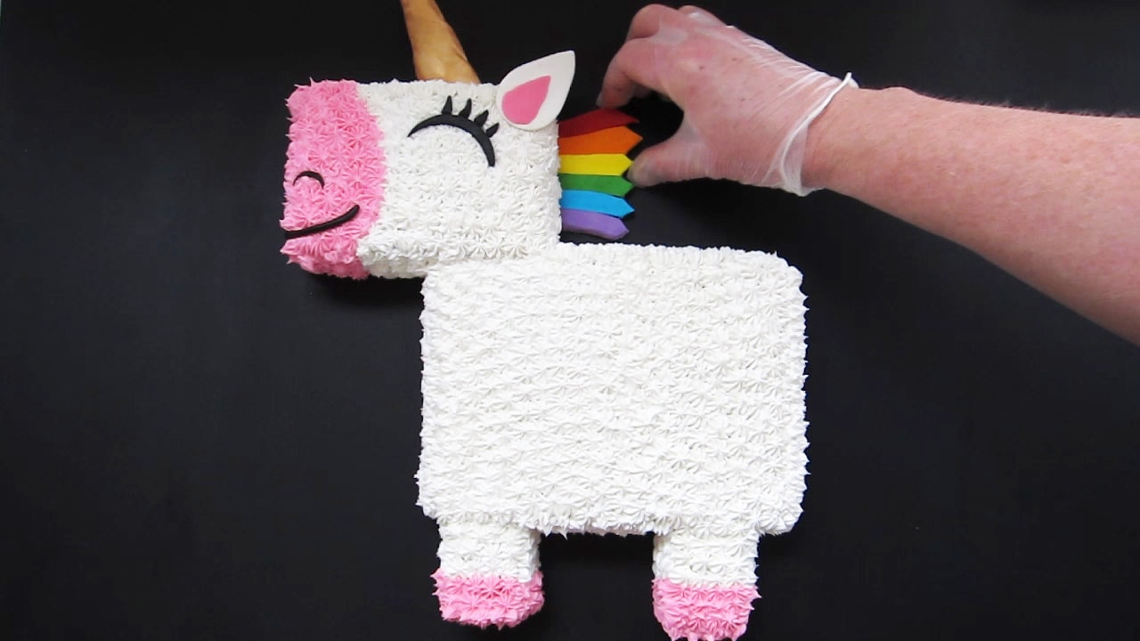 add a rainbow modeling chocolate mane to the cut-out unicorn cake.