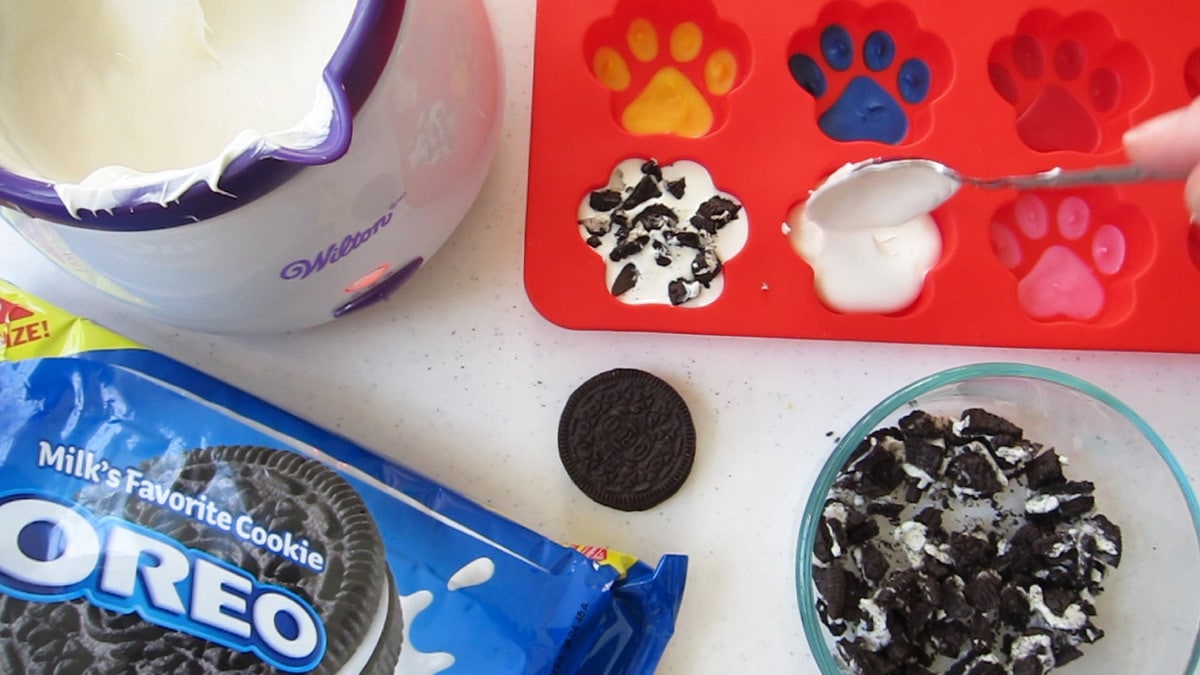 filling a painted paw mold with white chocolate