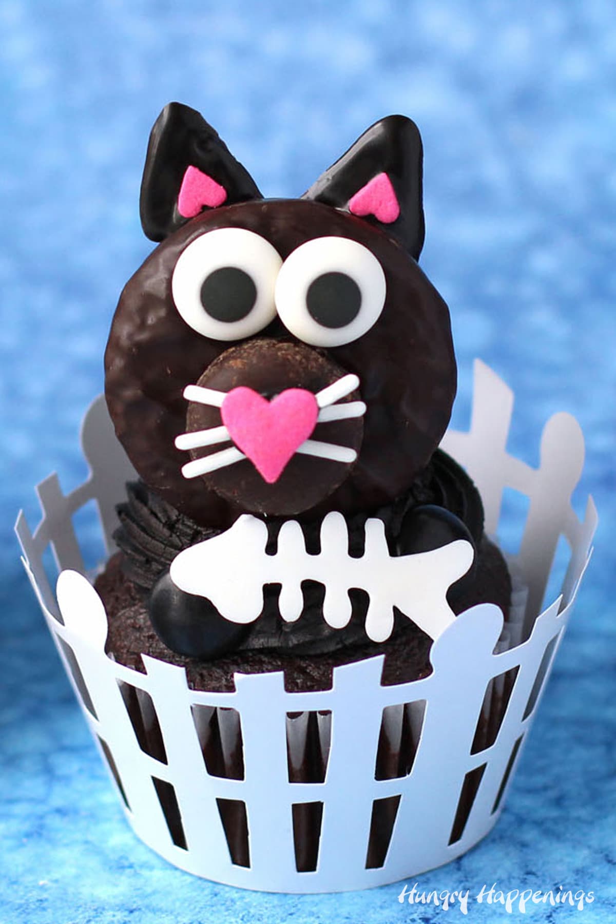 chocolate Halloween cat cupcakes topped with a swirl of black frosting, a Peppermint Patty cat, and white chocolate fish bones.