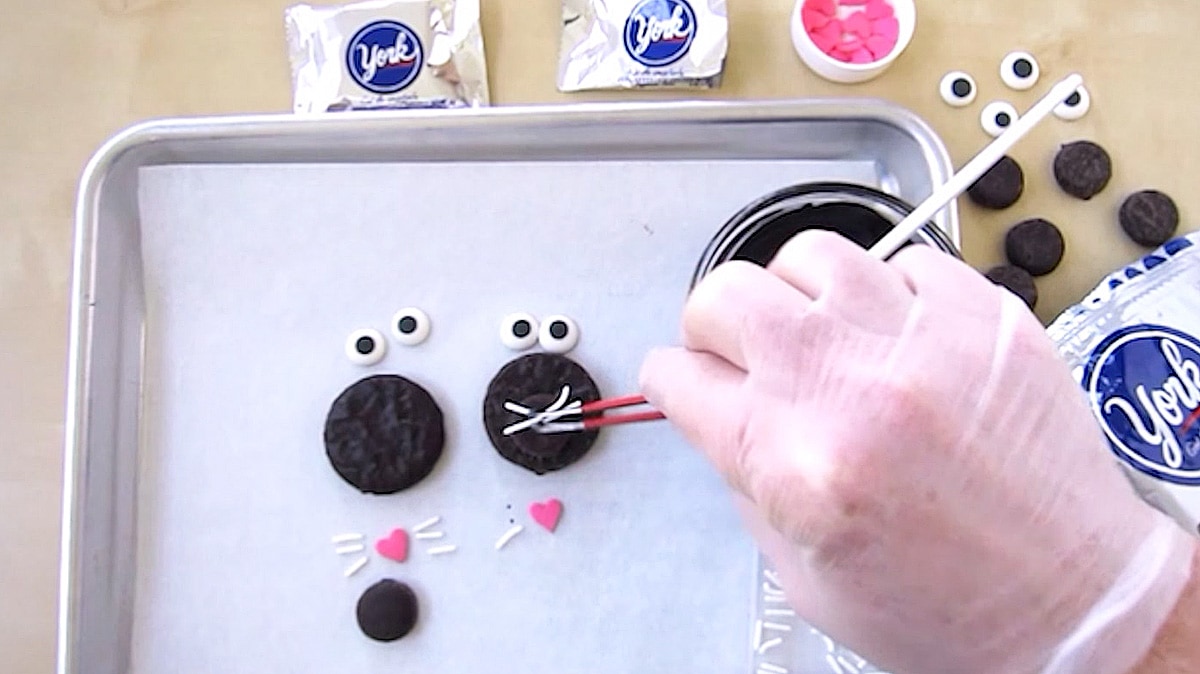 adding white sprinkle whiskers to the Peppermint Patty cats.