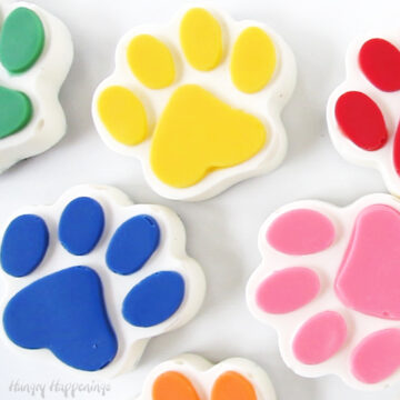 yellow, red, pink, orange, blue, and green-colored white chocolate paw patrol chocolate paws.