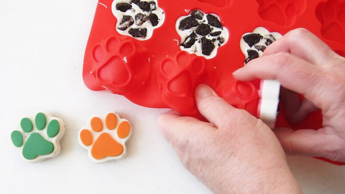 Un-molding the cookies and cream white chocolate paws from the silicone mold.