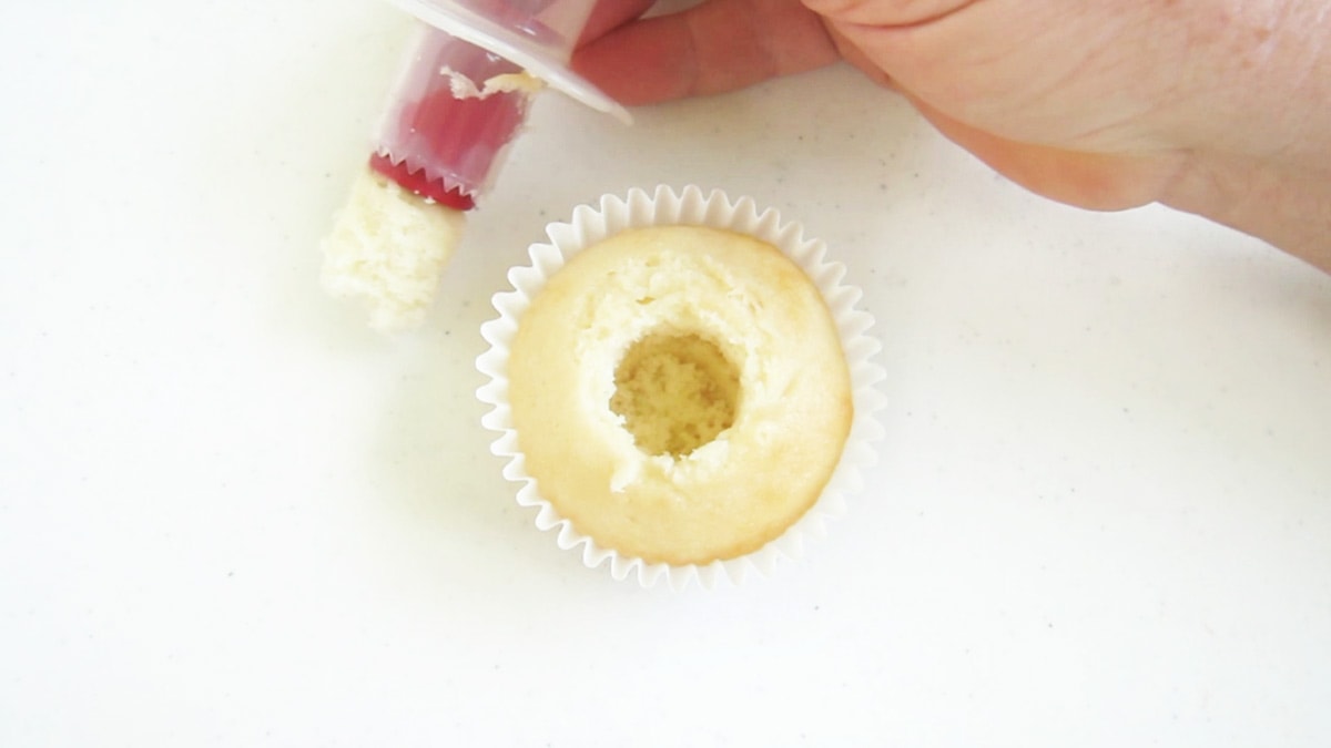 cut a well into a vanilla cupcake using a cupcake corer.