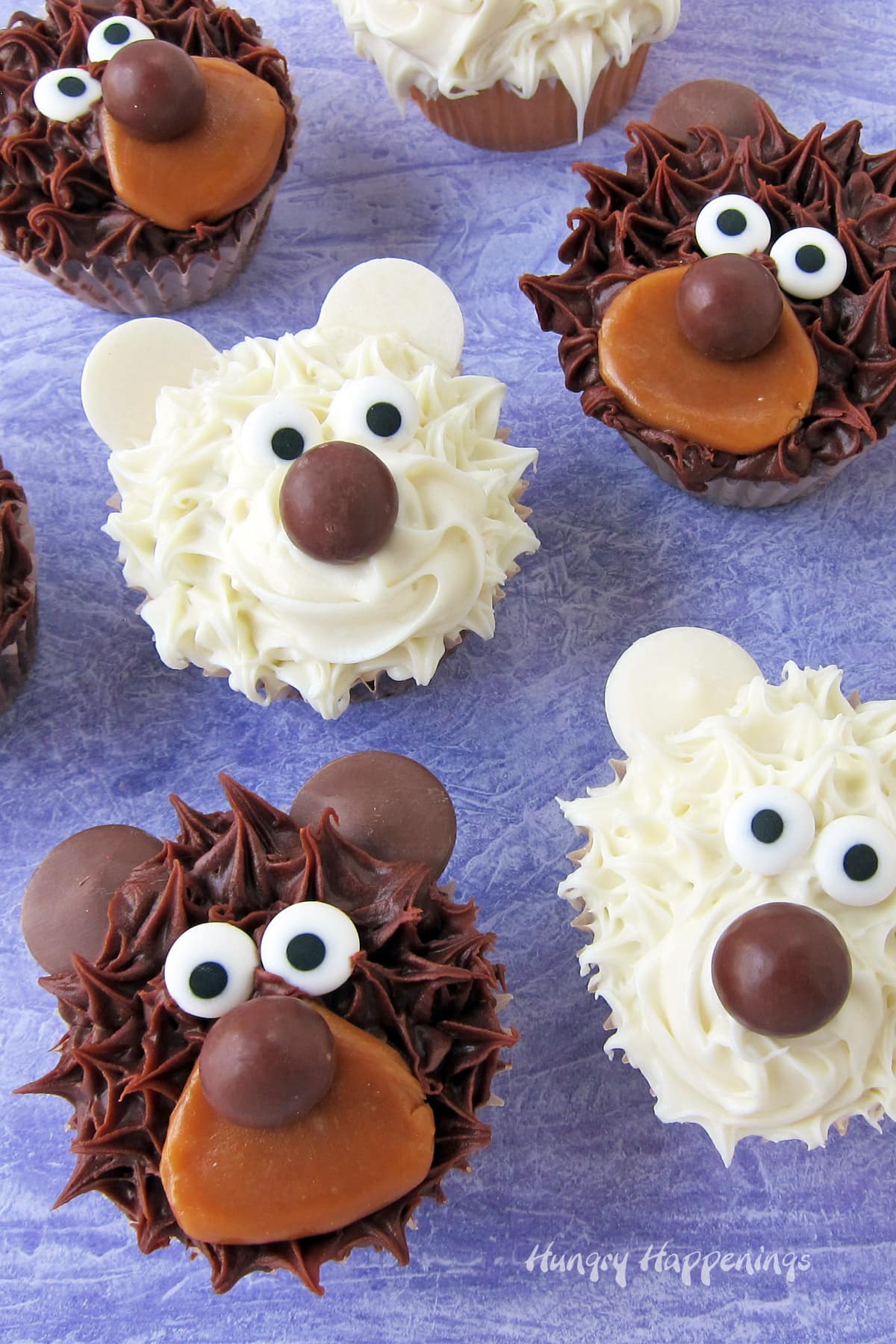 bear cupcakes featuring white polar bear cupcakes and brown grizzly bear cupcakes with candy eyes, chocolate noses, and caramel snouts.