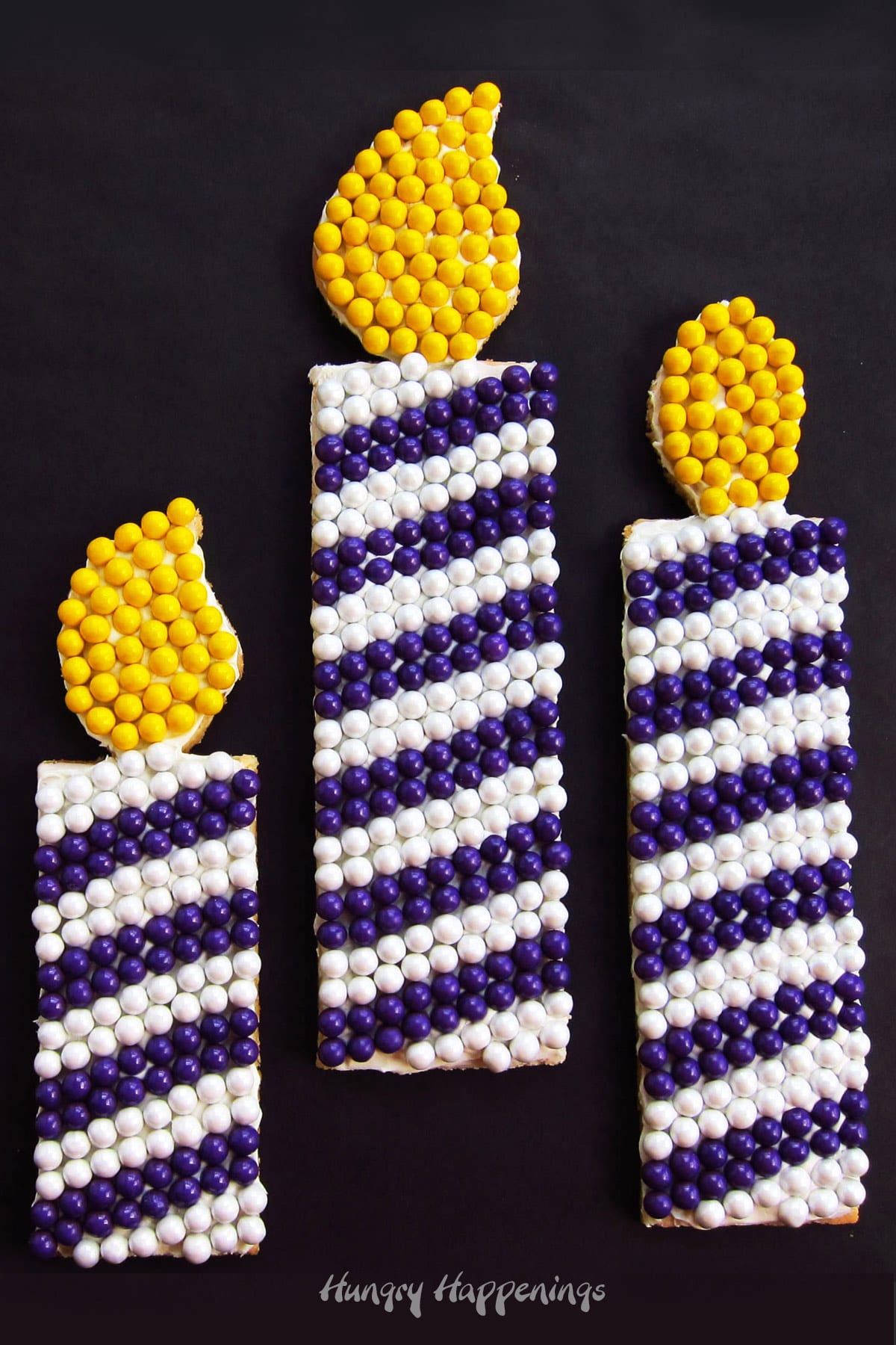blue and white striped birthday candle cookies decorated with rows of Sixlets.