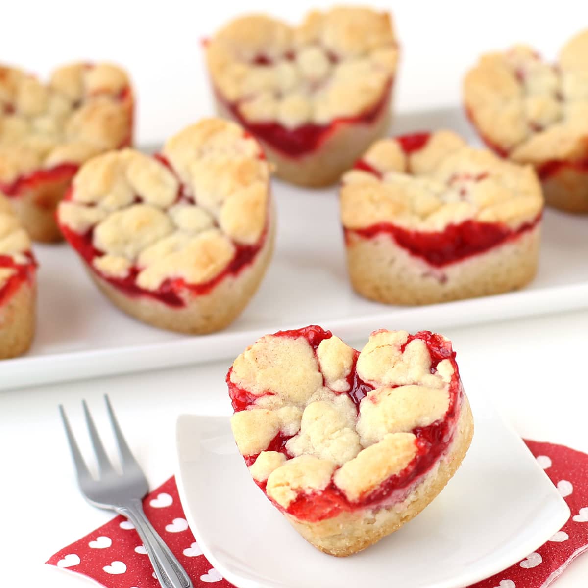 2-ingredient heart-shaped cherry pie bars served on white plates with a red and white Valentine's Day napkin.