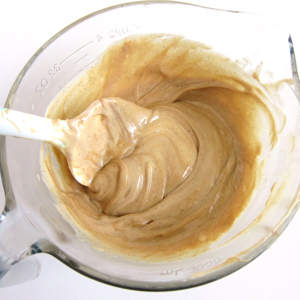 peanut butter fudge filling in mixing bowl stirred with a silicone spatula.
