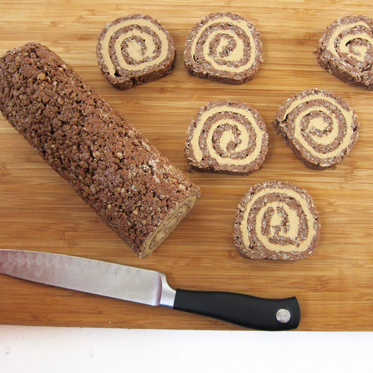 cutting chocolate peanut butter rice krispie treats into pinwheels.