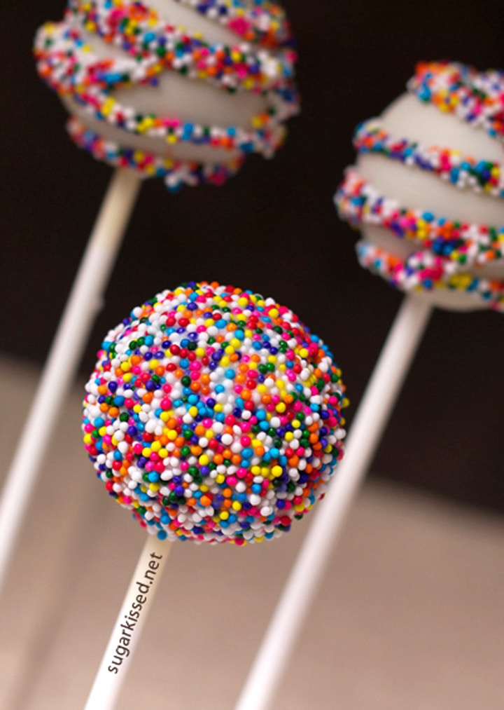 3 cake pops covered in rainbow nonpareils sprinkles
