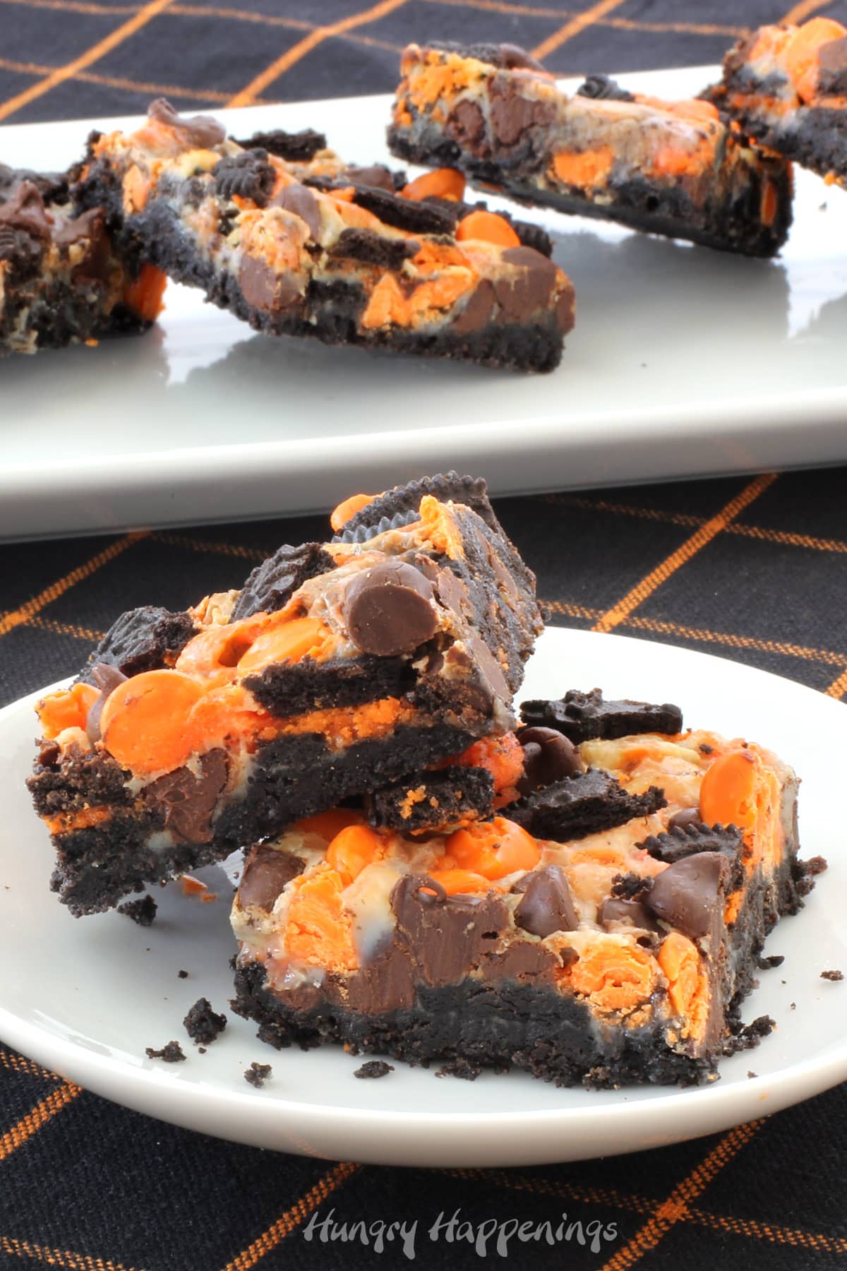 Halloween magic bars with an OREO Cookie crust topped with sweetened condensed milk, chocolate chips, orange chips, and Halloween Oreo cookie pieces.