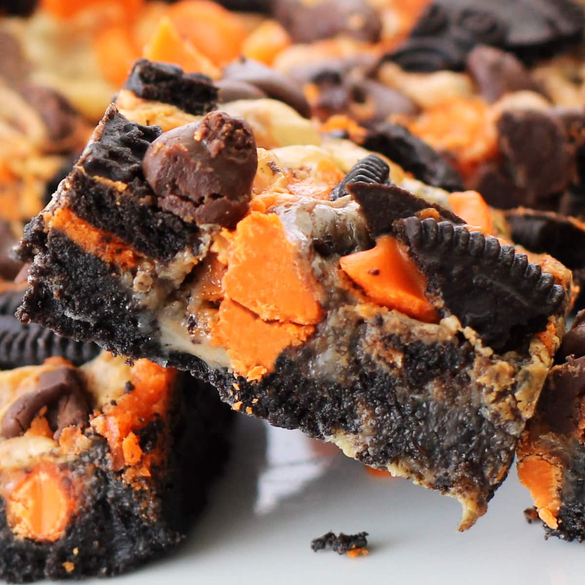 closeup of a Halloween OREO cookie bar filled with Halloween Oreos, orange and black chocolate chips, and sweetened condensed milk.