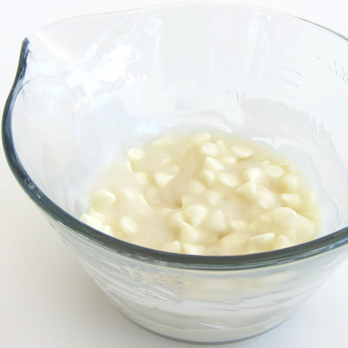 white chocolate mixed with cream of coconut in mixing bowl.
