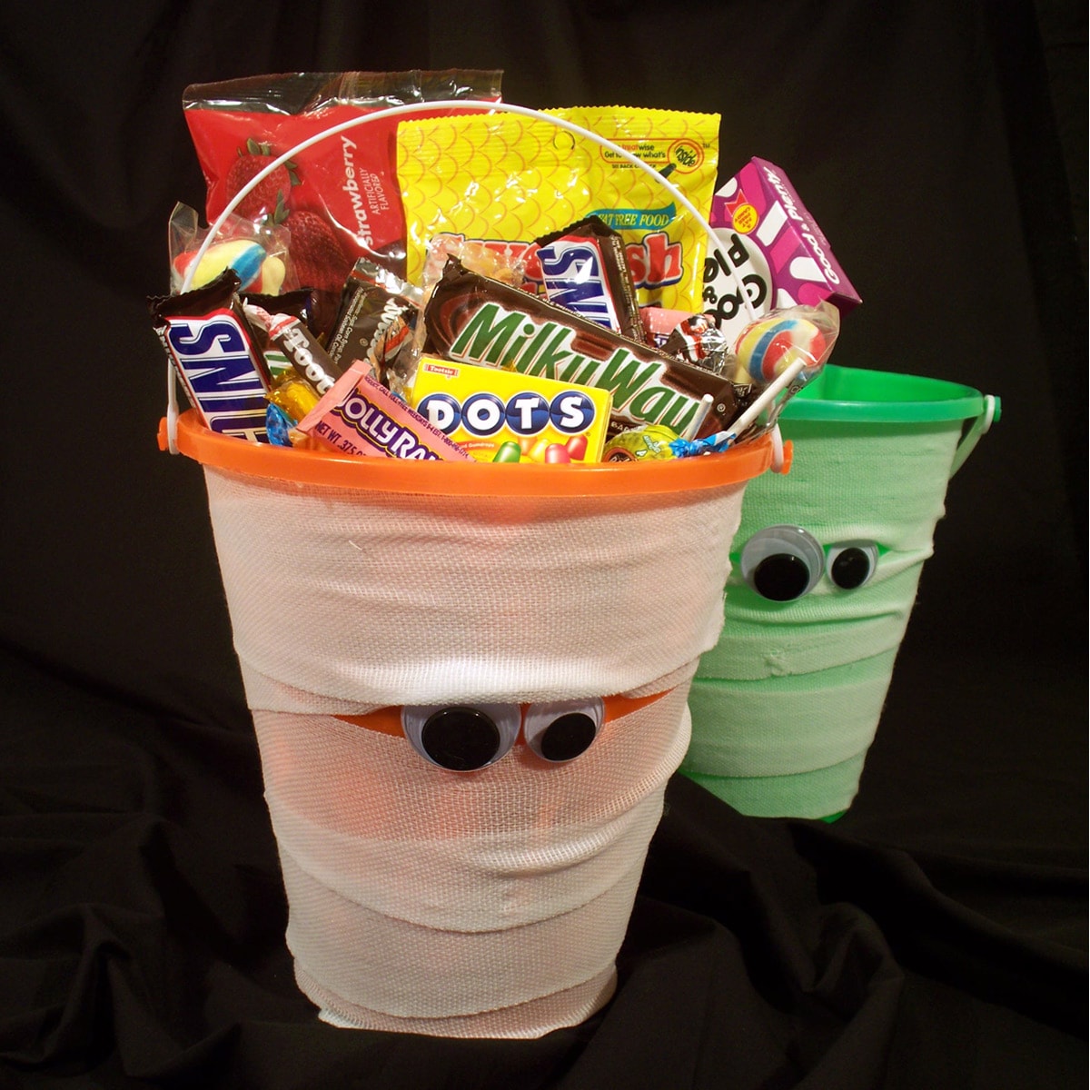 candy-filled orange and green mummy buckets wrapped in gauze with big googly eyes.