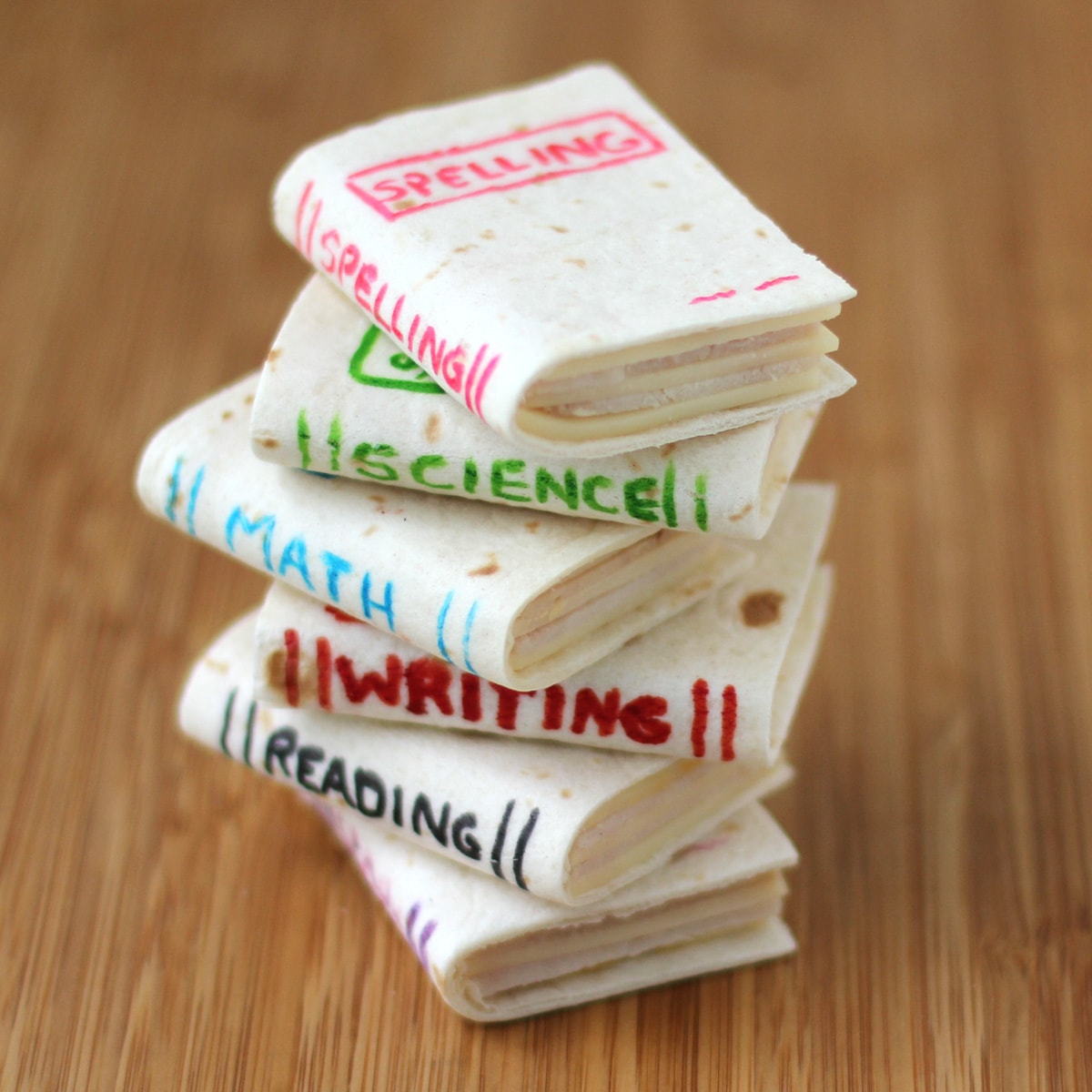 School book sandwiches made with soft tortillas printed with school book titles using food coloring .