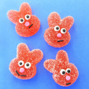homemade sour gummy bunnies with candy eyes, a pink sprinkle nose, and a black jimmy smile.