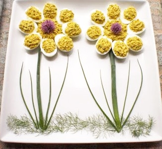 two deviled egg daisies on a square white platter. 