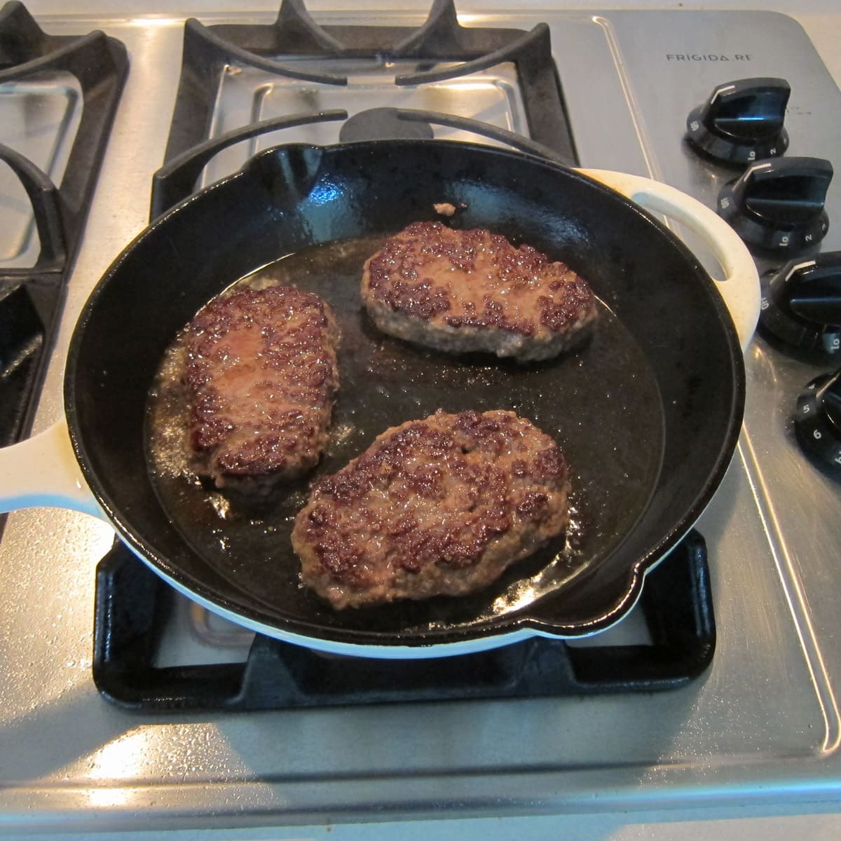 cooking skull-shaped hamburgers in a cast iron skillet.