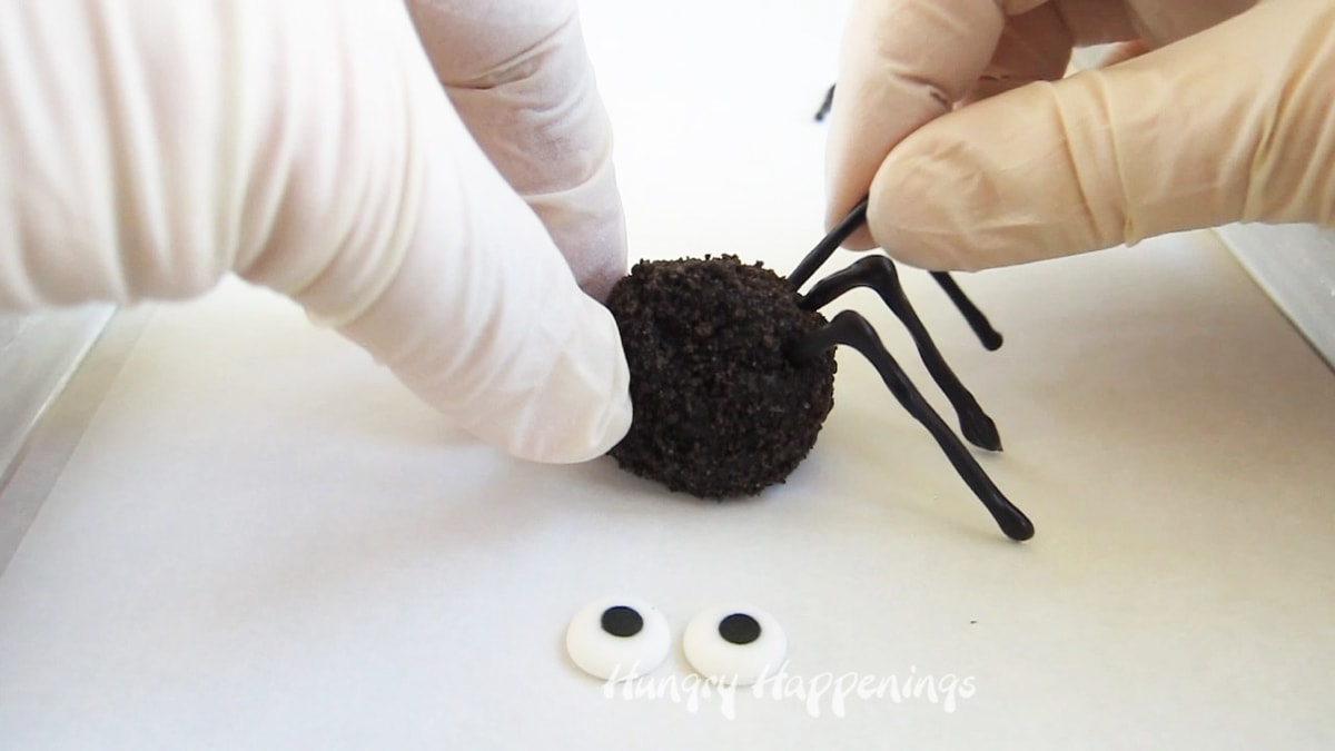 adding a chocolate spider leg to an oreo cookie ball spider.