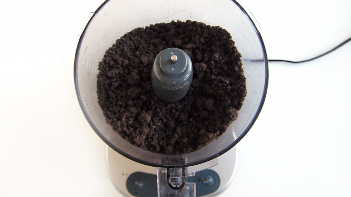 OREO Cookie crumbs in the bowl of a food processor.