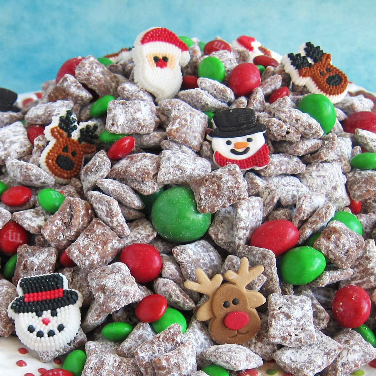 Christmas Puppy Chow filled with red and green M&M's, malt balls, and royal icing decorations. 
