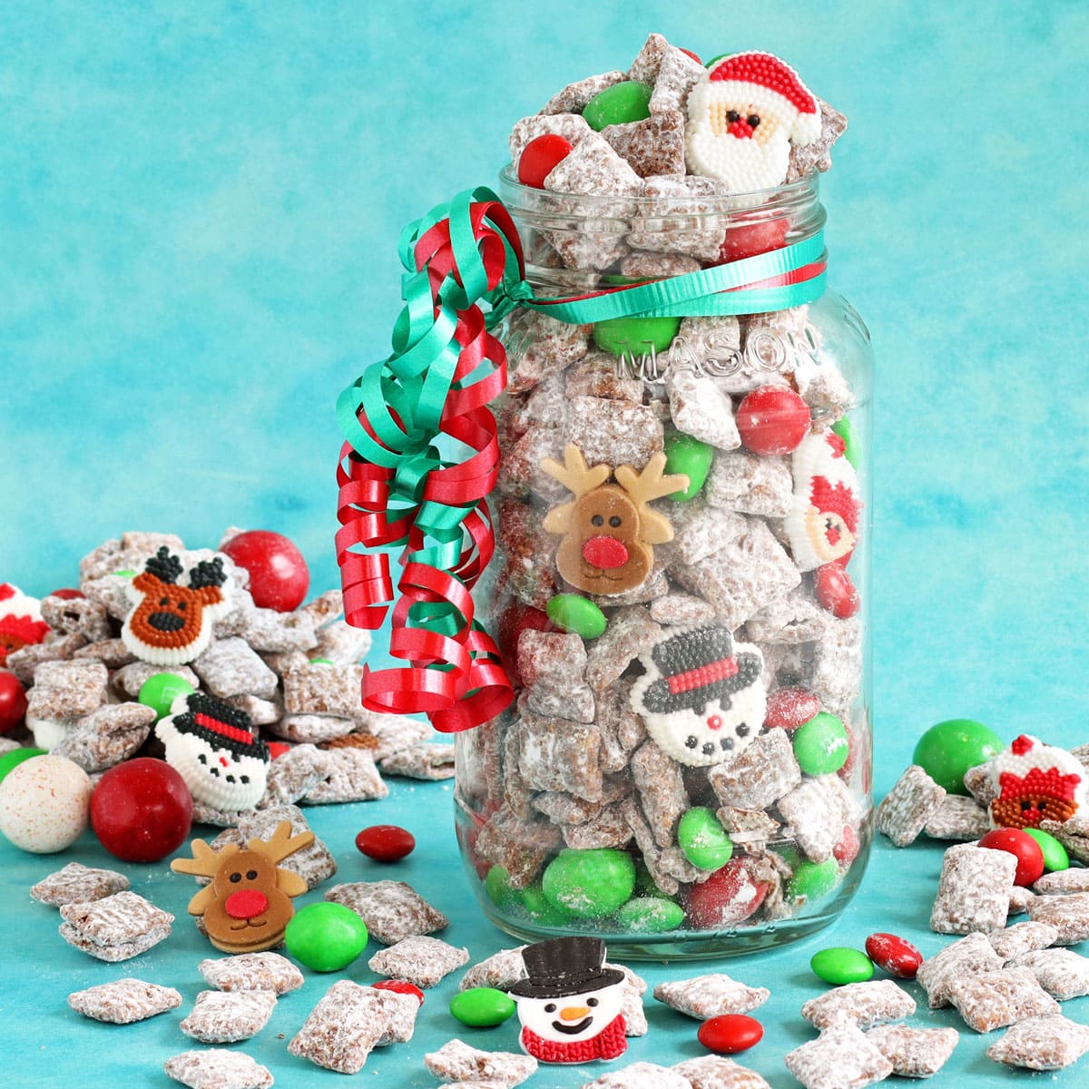 a large mason jar filled with Christmas muddy buddies (puppy chow).