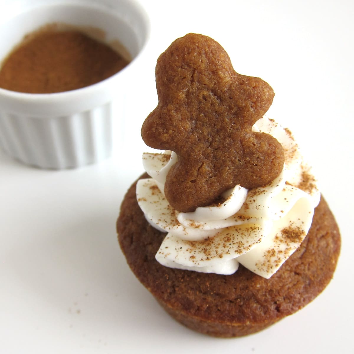gingerbread cookie cup topped with frosting, cinnamon, and a tiny gingerbread man.