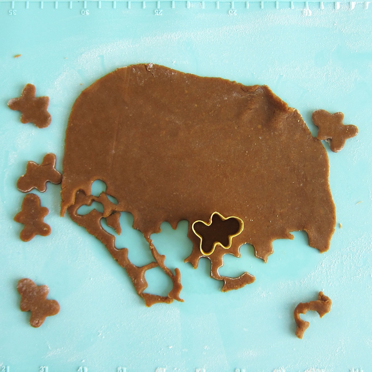 cutting gingerbread cookie dough using a small cookie cutter.