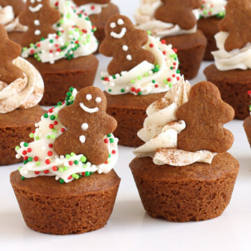 mini gingerbread cookie cups topped with frosting, Christmas sprinkles or cinnamon, and a tiny gingerbread man cookie.