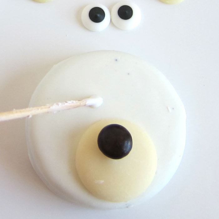 attaching a snout, nose, and eyes to a polar bear OREO using candy melts.