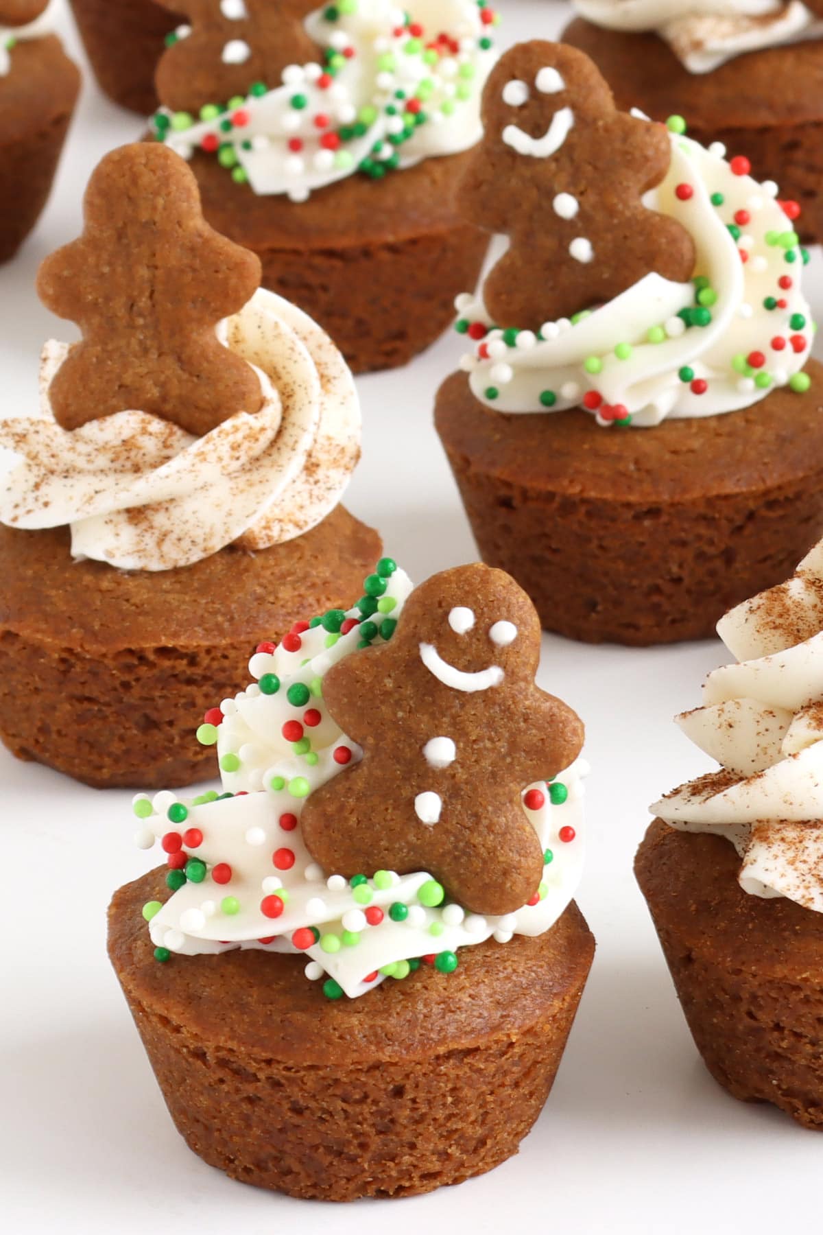 cute gingerbread cookie cups decorated with frosting, Christmas nonpareils, cinnamon, and tiny gingerbread cookie cups,