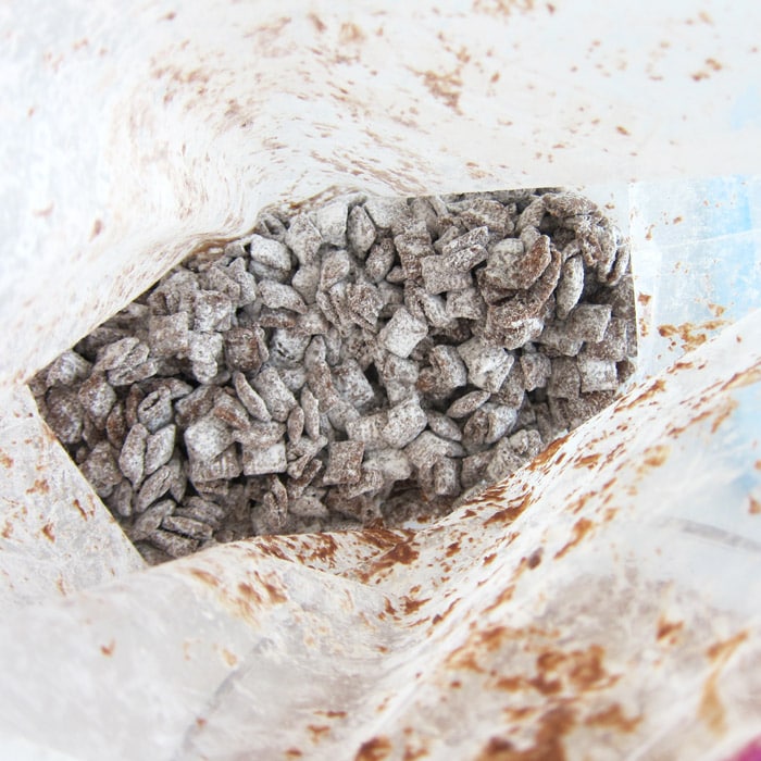 powdered sugar-dusted puppy chow inside a large zip-top bag.