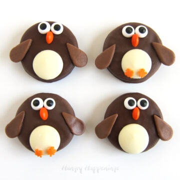 cute penguin OREOs made with Fudge Covered OREO Cookies decorated with candy eyes, orange M&M's, white candy melts, and leaf sprinkles.